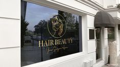 a store front window with the words beauty on it's side and an image of a woman