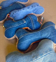 several pairs of blue jeans are laying on the floor with their feet propped up against each other