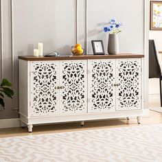 a white cabinet with cutouts on the doors and drawers in front of a table