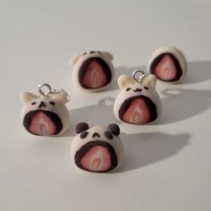 four small white and black bears with red letters on them's faces are shown in the shape of magnets