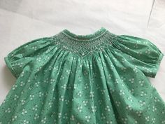 This Bishop Dress is a Size 6 Months. It is 100% Cotton. There is a placket in back with snaps for  closing and there is a generous hem.  All Smocking is done by hand. The joy of Bishop Dresses is the fact that the distance across the shoulders is less fitting and the baby can wear it a bit longer. Green Smocked Short Sleeve Dress For Daywear, Cotton Smocked Lined Dress For Daywear, Cotton Smocked Dress Lined For Daywear, Green Smocked Dress With Smocked Cuffs For Daywear, Fitted Smocked Dress For Gatherings, Green Cotton Smocked Short Sleeve Dress, Green Cotton Smocked Dress With Short Sleeves, Vintage Cotton Smocked Dress With Smocked Back, Vintage Cotton Dress With Smocked Back