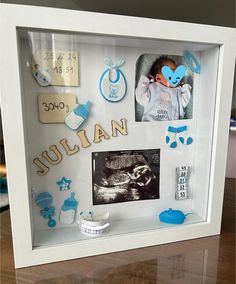 a baby's photo in a shadow box with its name and pictures on it