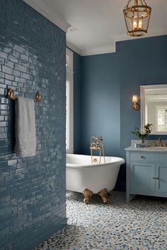 a bathroom with blue walls and a white bathtub in the middle of the room