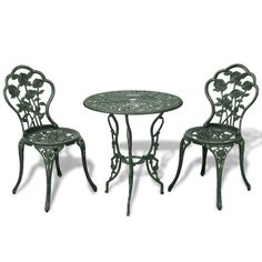 an iron table and two chairs with flowers on the back, against a white background