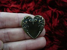 (Internal #B-Heart-13)  This is a heart shaped, piece of reproduction Victorian stamped brass with scrolled flower and dot design, made into a pin/pendant (glued on the back).  This gorgeous reproduction Victorian stamped brass is antiqued, then buffed to create some shine.  This pin/pendant is handcrafted. WE SHIP WORLDWIDE! Other accepted payment: Credit card (Mastercard/Visa/Discover) inquire for details. Antique Heart Brooch For Wedding, Antique Heart-shaped Wedding Brooch, Antique Gold Brass Brooch For Gift, Ornate Bronze Brooches For Gifts, Antique Heart-shaped Brooch For Gift, Antique Heart-shaped Brooches As Gifts, Antique Heart-shaped Brooches For Gifts, Victorian Brooch, Silver Brooch Pin