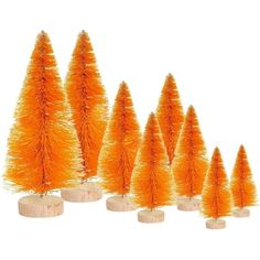 small orange christmas trees are lined up on wooden bases