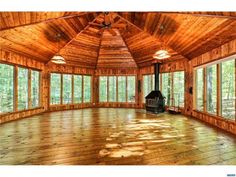 an empty room with wood floors and large windows in the ceiling, surrounded by trees