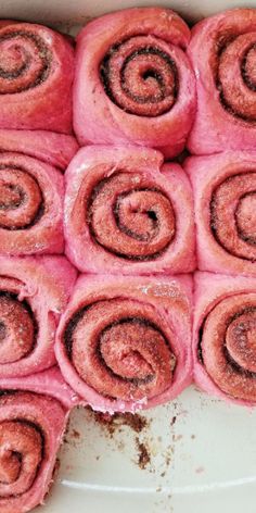 there are many pink rolls that have been rolled up on a plate and ready to be eaten