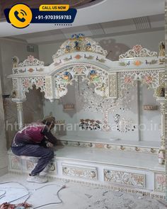 a man is working on a white bench in the middle of a room that has been painted