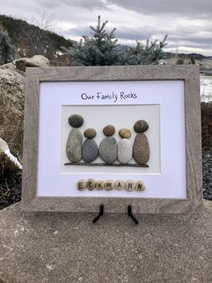 some rocks are sitting in a frame with the words'our family rocks'written on them