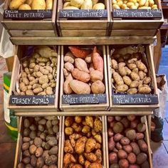 a display case filled with lots of different types of potatoes and sweet potato's