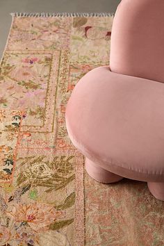 a pink chair sitting on top of a rug