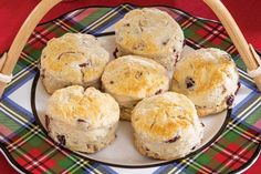 a plate full of scones on a red table cloth with a basket in the background