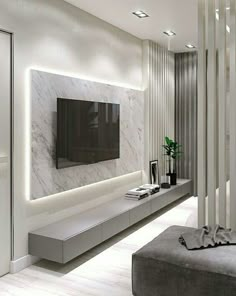 modern living room with white marble walls and flooring, large television on the wall