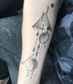 a woman's arm with a tattoo on it and an arrow in the middle