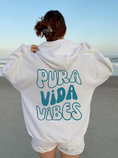 Retro groovy Pura Vida Vibes hoodie! Aesthetic/Trendy Hoodie will be a perfect gift for yourself, vacay matching team shirt/friend's birthday, holiday gifts, etc... Model is size M, but in the picture is wearing size XL Gildan 18500 hoodie for an oversized look. A unisex heavy blend hooded sweatshirt is relaxation itself. The material is a thick blend of cotton and polyester. This makes for a plush, soft feel alongside warmth. It's also a great surface for printing. There are no side seams. A spacious kangaroo pocket hangs in front. The hood's drawstring is the same color as the base sweater.  .: 50% cotton, 50% polyester .: Medium-heavy fabric (8.0 oz/yd² (271 g/m .: Classic fit .: Tear-away label .: Runs true to size Please note:   The order will be printed/shipped from printing company. Vsco Style Hoodie Sweatshirt With Letter Print, Winter Vsco Hoodie With Letter Print, Vsco Style Long Sleeve Hoodie With Letter Print, Casual Hooded Hoodie With Text Print, White Hoodie With Text Print Relaxed Fit, White Hoodie With Text Print In Relaxed Fit, White Relaxed Fit Hoodie With Text Print, White Vsco Style Letter Print Sweatshirt, Casual Hoodie With Lettering