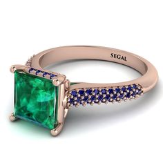 a ring with an emerald stone and diamonds on the side, set in 18k rose gold