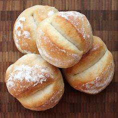 four round breads with powdered sugar on top