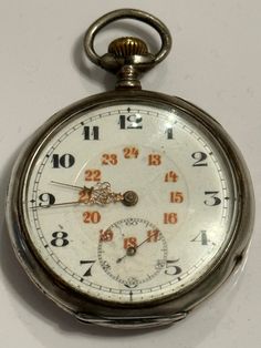 "Vintage pocket watch of the company \"Perfecta Fabrique d'Horlogerie Perfecta sa\", or abbreviated \"Simon PwC\". The watch is made of silver, include a porcelain enamel dial with the numbering of Arabic numbers for 12 hours, contrasting inclusion for 24 hours, as well as a minute chronograph. On the back, the watch is decorated with guilloche, as well as heraldic cartush for subsequent engraving and personalization. The diameter of the watch is 50mm. vintage swiss 1920s PWC pocket watch by Per Antique Silver Watch With Tachymeter, Silver Chronograph Pocket Watch For Formal Occasions, Arabic Numbers, Vintage Compass, Vintage Clocks, Clock Repair, Mechanical Hand, Vintage Pocket Watch, Watch Companies