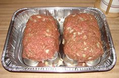 two hamburger patties sitting on top of tin foil in a baking pan, ready to be cooked