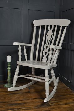 a white rocking chair sitting on top of a wooden floor