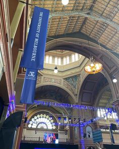 the inside of a large building with blue banners hanging from it's ceiling