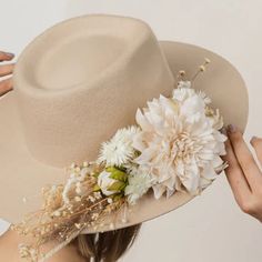 Our cream hat is made from 100% wool and is a quintessential fedora that will add at timeless elegance to any bridal ensemble. It features a teardrop crown with a stiff brim. Flower arrangements are made with real dried flowers, and come in small or large arrangements. Note: Champagne hat pictured is just to show large flower arrangement Details: 100% Wool Quintessential fedora Teardrop crown with a stiff brim Comes Plain, Small flower arrangement, Large flower arrangement Ivory Hat, Bridal Closet, Cream Hat, Bridal Party Getting Ready, Small Flower Arrangements, Large Flower Arrangements, Bridal Hat, Wedding Dress Shopping, Wedding Bridesmaid Dresses