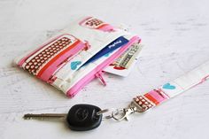 a key chain is attached to a wallet with a card holder and keys in it