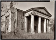 an old house with columns and pillars in the grass