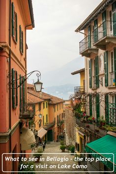 an alley way with lots of buildings and green shutters on both sides, surrounded by greenery