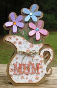 a mother's day card with flowers in a teapot and the word mom on it