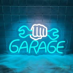 a neon sign that says garage in front of a brick wall