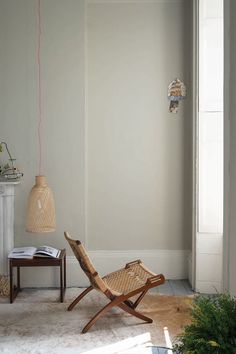 a chair and table in a room with a light fixture on the wall above it