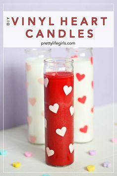 two candles sitting next to each other with hearts on them