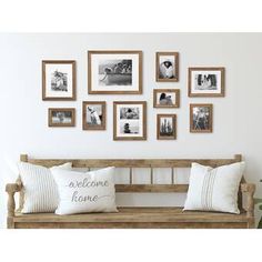 a wooden bench sitting in front of a wall filled with pictures