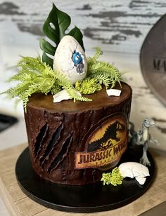 there is a cake decorated with plants and an egg in the middle on top of a table