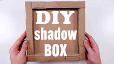 someone holding up a cardboard box with the words diy shadow box on it in front of them