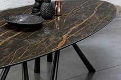 a marble table with two vases on it and one bowl sitting on the table