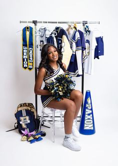 a cheerleader sitting on a chair with her pom poms in front of her