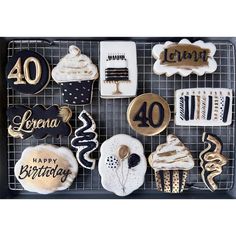 cookies decorated with gold and black are arranged on a cooling rack for celebrating forty birthdays