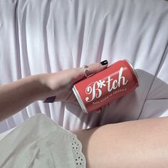 a woman is holding a can of beer