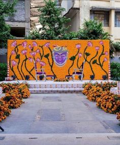 an artistic display in front of a building with flowers and plants on the side walk