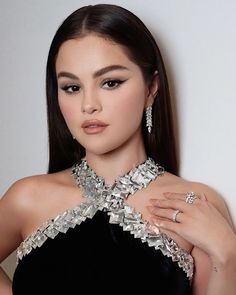 a woman wearing a black dress and diamond jewelry