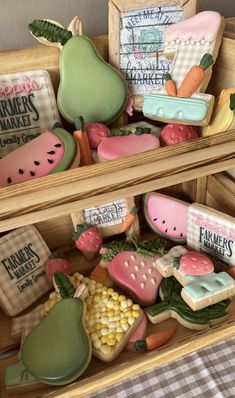 some cookies are in a wooden box on a checkered tablecloth and there is a sign that says farmers market next to it