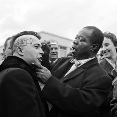 a group of people standing next to each other with faces painted on their foreheads