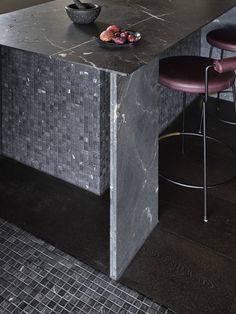 a black marble kitchen island with purple chairs