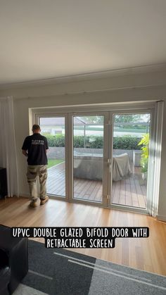 a man standing in front of a sliding glass door with the words upvc double glazed fold door with retractable screen