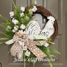 a wreath that is hanging on the front door with a chicken and chick's nest