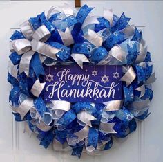 a happy hanukkah wreath with blue and silver ribbons on the front door