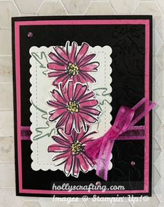 a close up of a card with pink flowers on black and white paper, tied to a brick wall